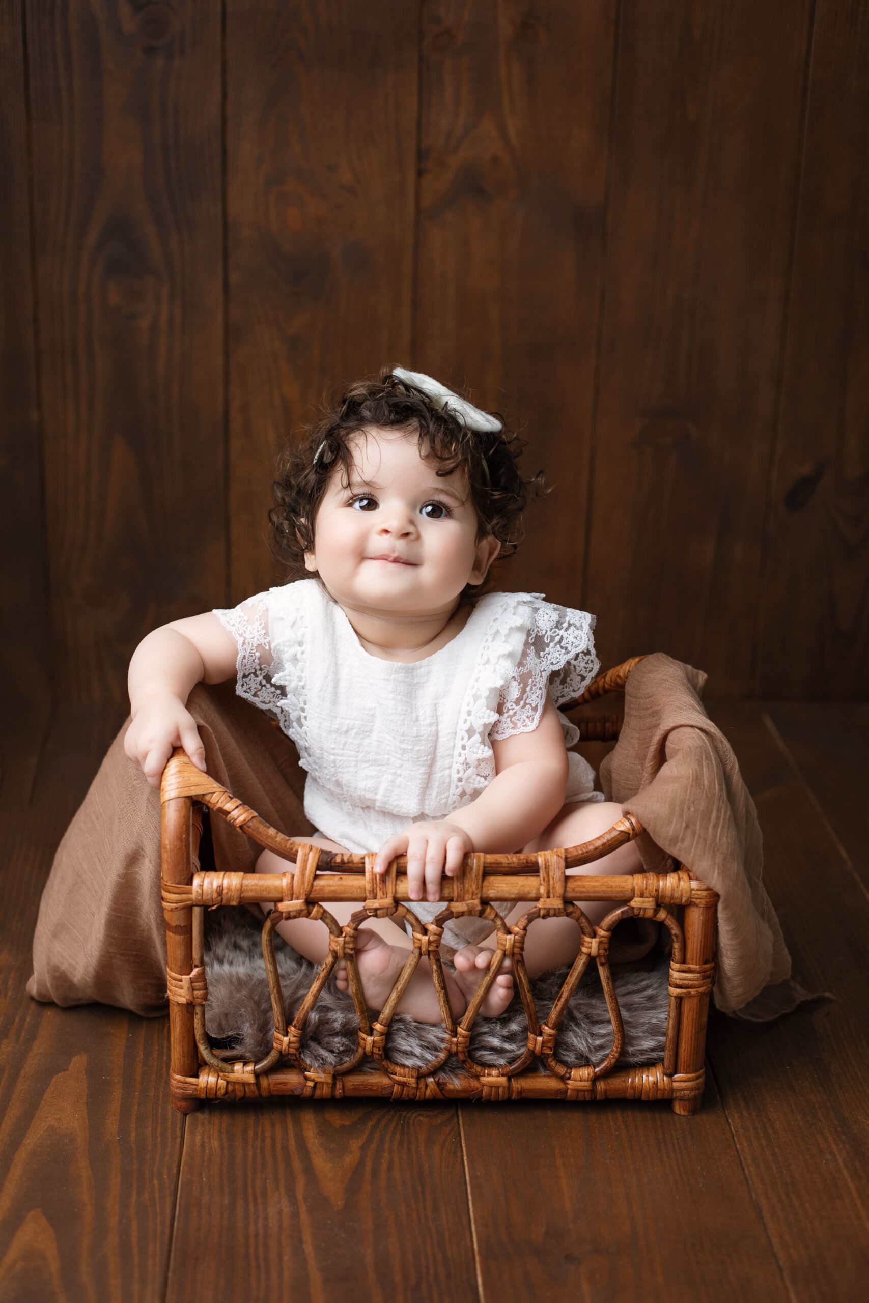 B&eacute;b&eacute; de 6 mois dans son panier sur fond bois &ndash; photographe Sourzac