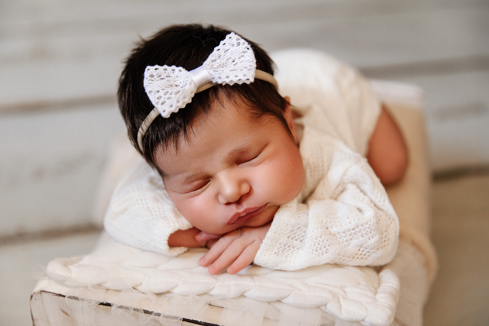 Nouveau-n&eacute; pos&eacute; dans un lit en bois blanc &ndash; photographe naissance P&eacute;rigueux